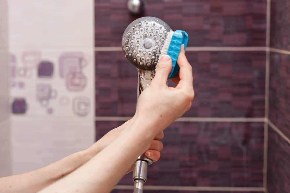 Remove the shower head and clean it with your hand or a toothbrush